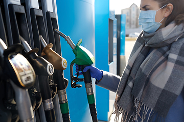 Image showing young woman wearing medical mask at gas station