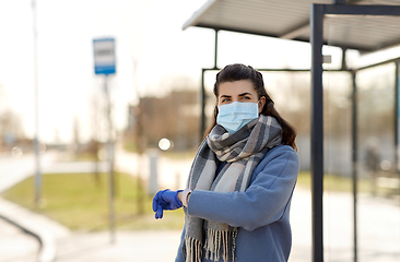 Image showing woman in mask with wristwatch at bus stop