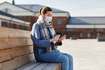 Image showing woman in mask spraying hand sanitizer outdoors