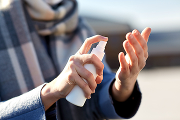 Image showing close up of woman spraying hand sanitizer