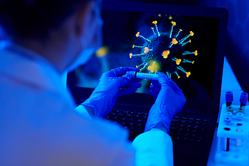 Image showing hand holding beaker with coronavirus blood test