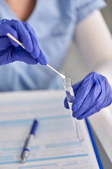 Image showing hands in gloves holding test tube and cotton swab