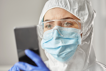 Image showing doctor in protective wear with smartphone