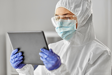 Image showing doctor in protective wear with tablet computer