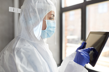 Image showing doctor in protective wear with tablet computer