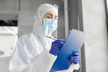 Image showing doctor in medical mask and shield with clipboard