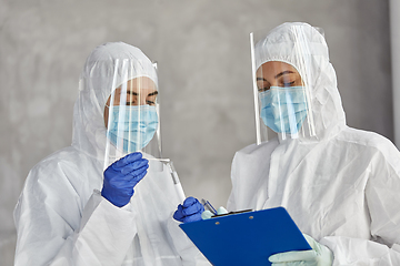 Image showing doctors in medical mask and shield with clipboard