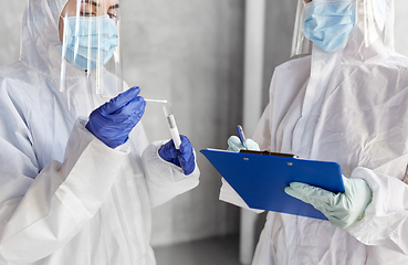 Image showing doctors in medical mask and shield with clipboard