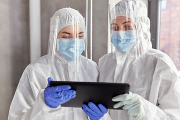 Image showing doctors in protective wear with tablet computer