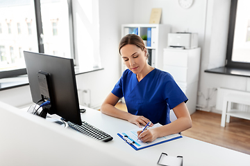 Image showing doctor or nurse with clipboard working at hospital