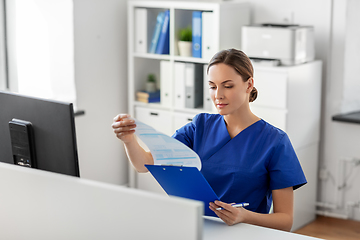 Image showing doctor or nurse with clipboard working at hospital