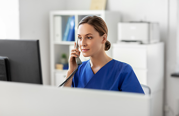 Image showing doctor with computer calling on phone at hospital