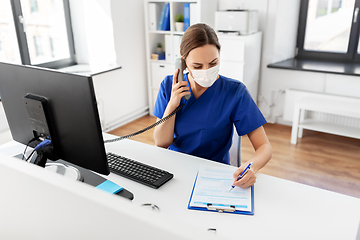 Image showing doctor with computer calling on phone at hospital