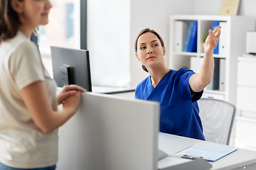 Image showing doctor showing something to patient at hospital