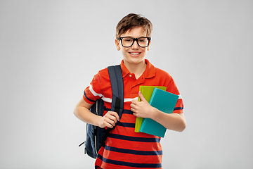 Image showing smiling student boy with backpack and books