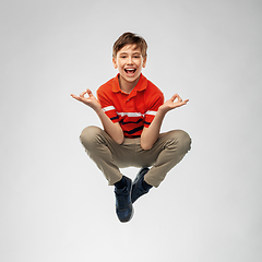 Image showing happy smiling young boy flying in air in yoga pose