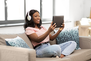 Image showing woman with tablet pc listening to music at home