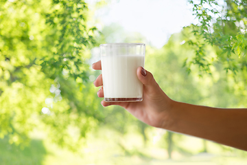 Image showing close up of female hand holding glass of milk