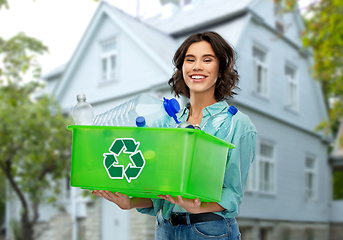 Image showing smiling young woman sorting plastic waste outdoors