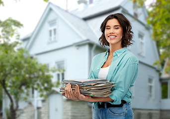 Image showing smiling young woman sorting paper waste outdoors