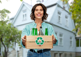 Image showing smiling young woman sorting glass waste outdoors