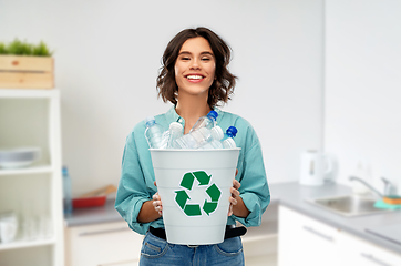 Image showing smiling young woman sorting plastic waste at home