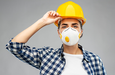 Image showing female worker or builder in helmet and respirator