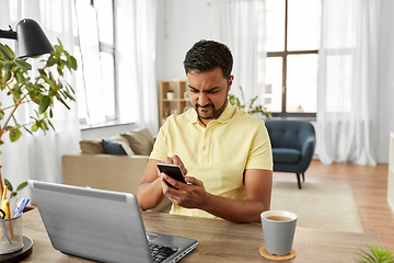 Image showing indian man with smartphone at home office