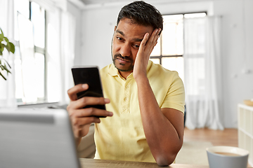 Image showing indian man with smartphone at home office