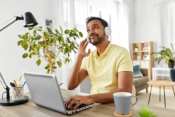 Image showing man in headphones with laptop working at home