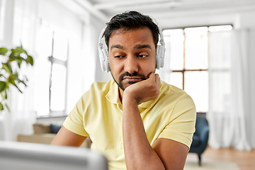 Image showing man in headphones with laptop working at home