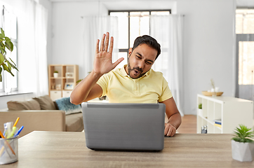 Image showing man with laptop has video chat and makes high five