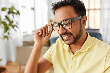 Image showing happy smiling indian man in glasses at home office