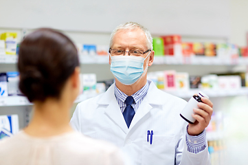 Image showing apothecary in mask with drug and woman at pharmacy