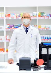 Image showing old apothecary in mask at pharmacy cash register