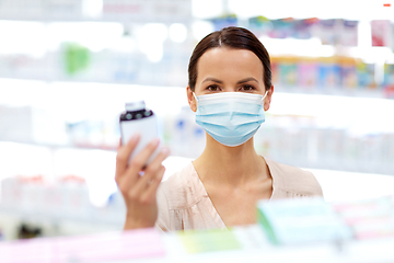 Image showing female customer in mask with medicine at pharmacy