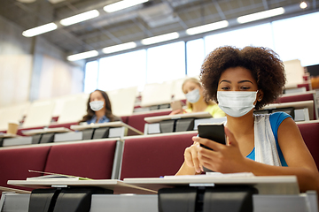 Image showing student girl in mask with smartphone at lecture