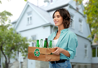 Image showing smiling young woman sorting glass waste outdoors