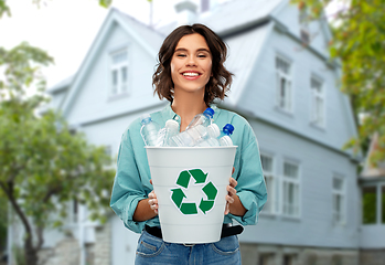 Image showing smiling young woman sorting plastic waste outdoors