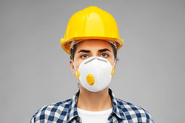 Image showing female worker or builder in helmet and respirator