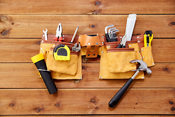 Image showing different work tools in belt on wooden boards