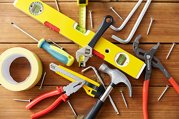 Image showing different work tools on wooden boards background