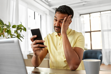 Image showing indian man with smartphone at home office