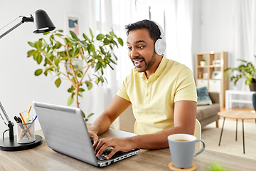 Image showing man in headphones with laptop working at home