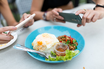 Image showing Friends taking photo on thai food dishes before eating