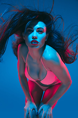 Image showing Attractive brunette model on blue studio background in neon light