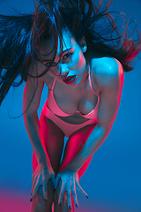 Image showing Attractive brunette model on blue studio background in neon light