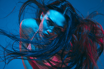 Image showing Attractive brunette model on blue studio background in neon light