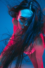 Image showing Attractive brunette model on blue studio background in neon light