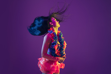 Image showing Attractive hawaiian brunette model on purple studio background in neon light